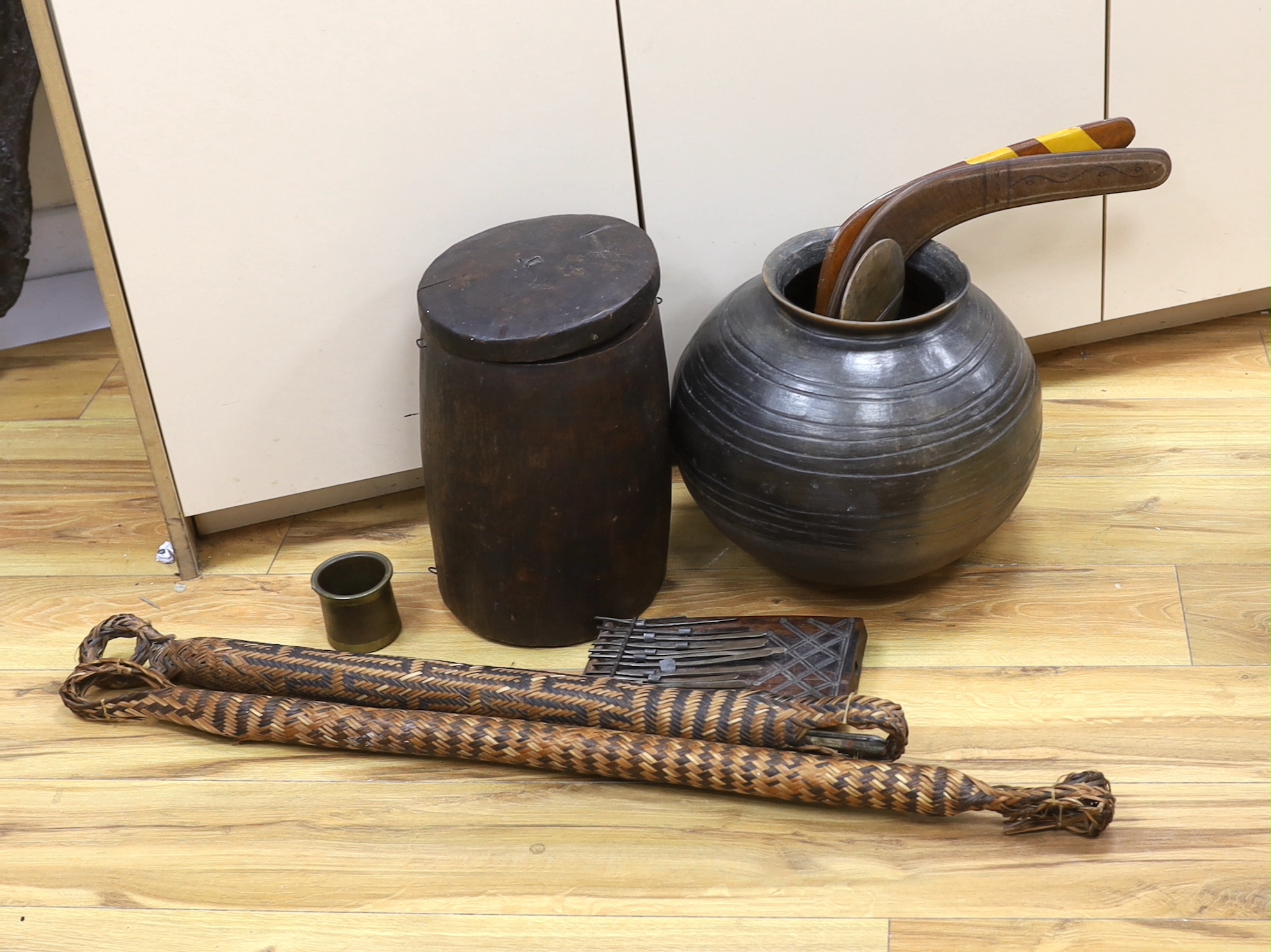 An earthenware bowl, two woven arrow quivers, a bronze pot, a wooden pot and lid, a fertility figure, two boomerangs, etc. (9)